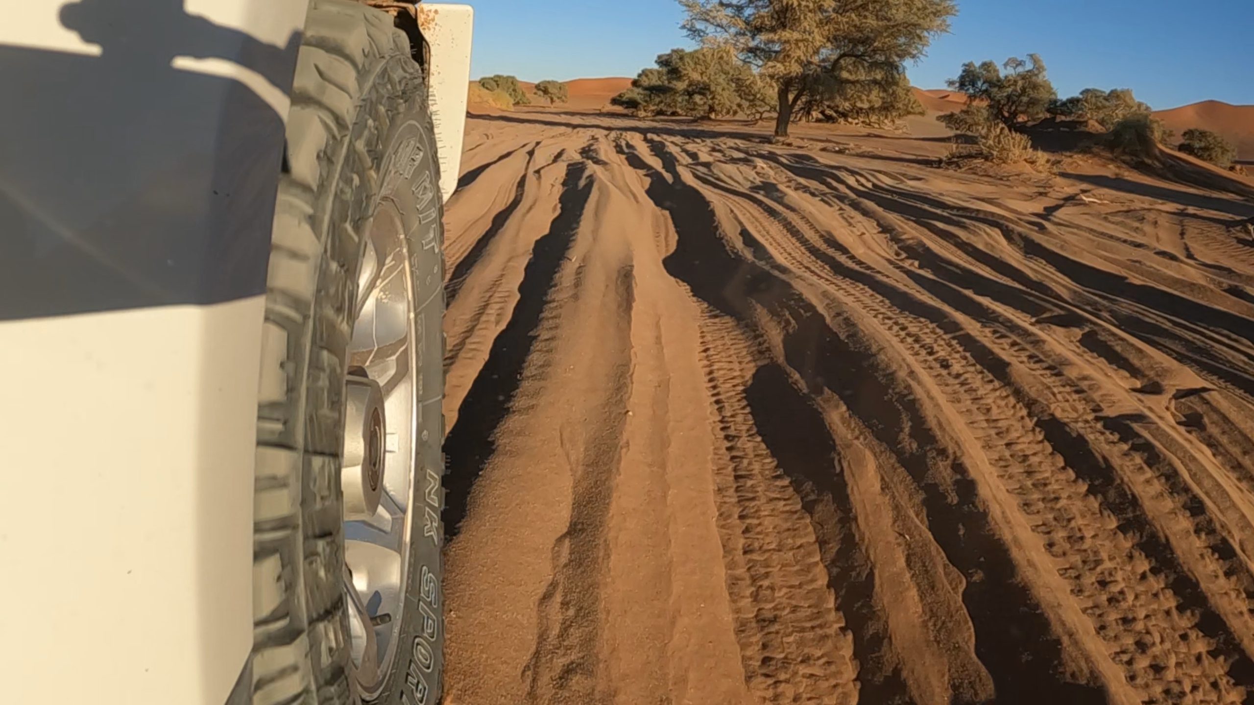 Tracce di pneumatici 4x4 sulla sabbia rossa di Sossusvlei in Namibia, gravel road verso Deadvlei
