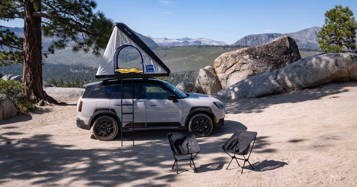 MINI Countryman Untamed Edition su uno sterrato di montagna con la tenda da tetto Autohome aperta e due sedie da campeggio